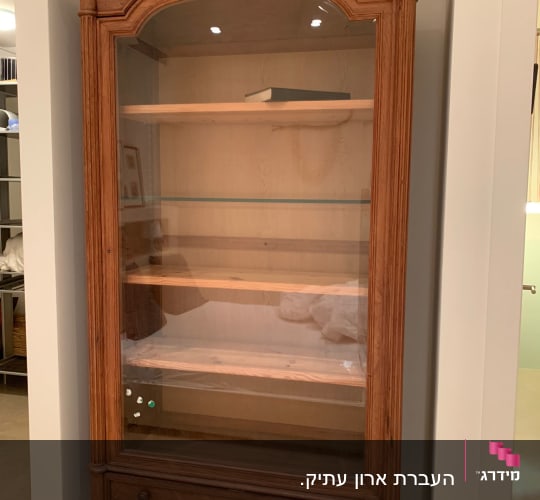 ארון עץ עם דלת זכוכית ומדפים פנימיים